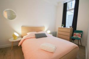 um quarto com uma cama grande e um cobertor rosa em Lille Gares - 50m2 apartment! em Lille