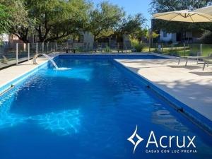 una gran piscina azul con sombrilla en Casas Acrux en Nono