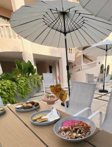 una mesa con platos de comida y una sombrilla en Del Trópico sopetrán en Sopetran