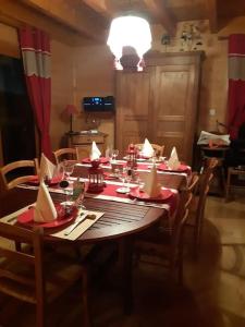 een eetkamer met een tafel met rode servetten erop bij Chalet, Murat (nouveau logement) in Murat