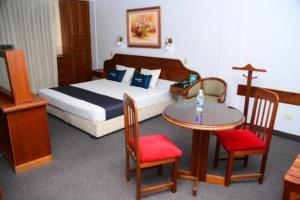 um quarto de hotel com uma cama, uma mesa e cadeiras em GLORIA PLAZA HOTEL em Chiclayo