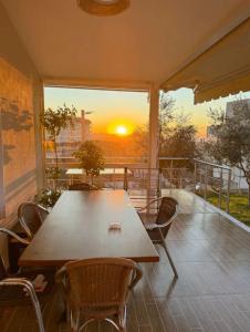 a table and chairs on a balcony with a sunset at Villa Nikol in Tirana