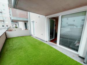 a balcony with a green lawn in a building at Vienna Cosy Apartment 107 in Vienna