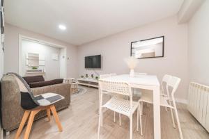 sala de estar con mesa blanca y sillas en Elegant 6 pax apartment in Plaza Eliptica - SM17, en Madrid