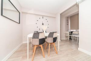comedor con mesa y sillas en Elegant 6 pax apartment in Plaza Eliptica - SM17, en Madrid