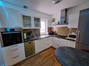 eine Küche mit weißen Schränken und Küchengeräten aus Edelstahl in der Unterkunft modern und gemütlich in Linden