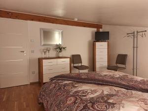 ein Schlafzimmer mit einem Bett, einer Kommode und 2 Stühlen in der Unterkunft modern und gemütlich in Linden