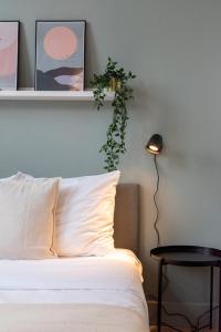 1 dormitorio con 1 cama con una planta en la pared en Lille Centre - Nice and functional ap., en Lille