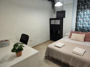 a room with a bed and a table with a plant on it at Atico Queen Itimad in San Juan de Aznalfarache