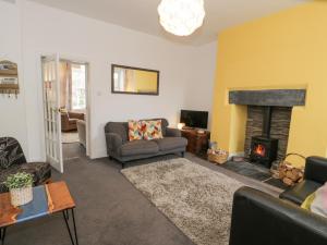 a living room with a couch and a fireplace at Swn Yr Afon in Tywyn