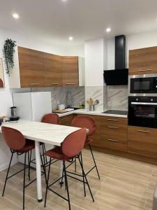 a kitchen with a white table and four chairs at Sublime T2/ Cosy/ Clim/ Parking/Plage in Menton