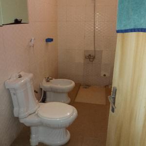 トゥバブ・ディアラオにあるChez Mimiのバスルーム(白いトイレ、シャワー付)