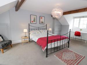 a bedroom with a black bed with a red blanket at Swn Yr Afon in Tywyn