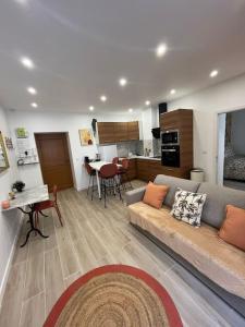 ein Wohnzimmer mit einem Sofa und einer Küche in der Unterkunft Sublime T2/ Cosy/ Clim/ Parking/Plage in Menton