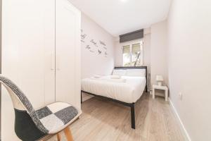 a bedroom with a bed and a chair at Elegant 6 pax apartment in Plaza Eliptica - SM17 in Madrid