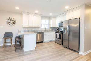 a kitchen with white cabinets and a stainless steel refrigerator at Rejuvenation and Relaxation in Virginia Beach