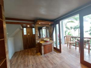 een woonkamer met houten vloeren en een groot raam bij Prema Shiva Suites and Villas by EPS in Ubud