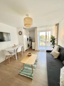 a living room with a couch and a table at Appartement Cosy - Cap d'Agde proche plage et port - Parking in Cap d'Agde