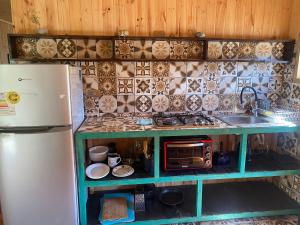 a small kitchen with a refrigerator and a microwave at Refugio Nomade Apartamentos in Pichilemu