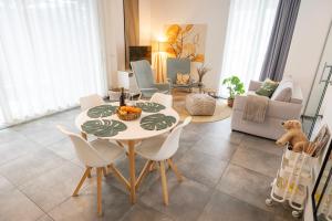 a dining room with a table and chairs in a living room at Residenz - Haus Erde - Penthouse - Sauna - Parkplatz in Bad Zwischenahn