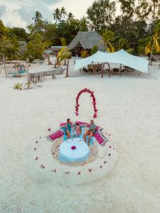 two people playing in a sand pit on the beach at Sharazad Oasis Retreat in Jambiani