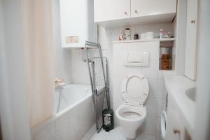 a white bathroom with a toilet and a bath tub at Vienna Stadthalle Apartment 19 in Vienna