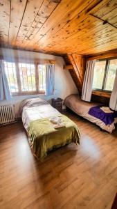 um quarto com uma cama num chalé de madeira em Achalay Houses em San Carlos de Bariloche