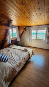 duże łóżko w pokoju z drewnianymi sufitami w obiekcie Achalay Houses w mieście Bariloche