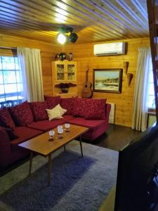 a living room with a red couch and a table at Lapikas in Kallo