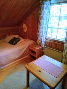 een slaapkamer met een bed, een tafel en een raam bij Lapikas in Kallo
