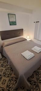una camera da letto con un letto con due asciugamani sopra di Studio Bandiera apartment a Palermo