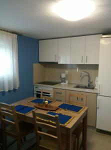 a kitchen with a wooden table and a white refrigerator at Vaso apartment Limenaria Thasos in Limenaria