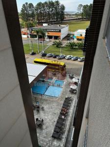 - une vue sur un bâtiment avec une piscine et un parking dans l'établissement Spazzio diRoma com acesso ao Acqua Park - Adriele, à Caldas Novas