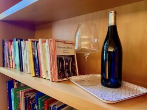 uma garrafa de vinho e um copo numa estante de livros em The L i b r a r y em Bérgamo