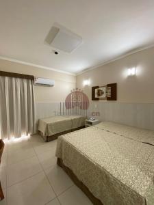 una camera d'albergo con due letti e una finestra di Spazzio diRoma com acesso ao Acqua Park - Adriele a Caldas Novas