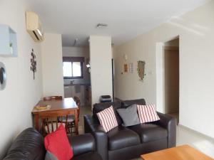 a living room with a leather couch and a table at BarLee's Apartment in Paralimni