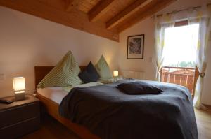 a bedroom with a bed and a large window at Feriendorf Via Claudia Haus 62 Bernhard in Lechbruck