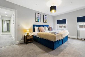 a bedroom with a blue bed and a night stand at WhiskAwayStays - Victoria House - Apartment 5 in Worcester