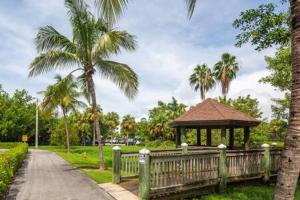 a wooden fence with a gazebo and palm trees at Salt Pond Hideaway 133 by Brightwild in Key West