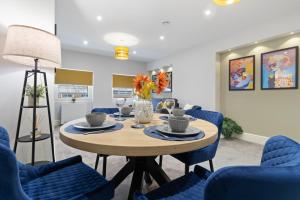 a dining room with a table and blue chairs at WhiskAwayStays - Victoria House - Apartment 5 in Worcester
