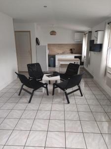 ein Wohnzimmer mit 2 Stühlen und einem Tisch in der Unterkunft Résidence Les Hauts de France in Noeux-les-Mines