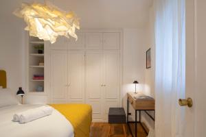 um quarto com uma cama, uma secretária e um lustre em Coqueto apartamento, céntrico, con garaje y piscina by Prishomes em Vigo