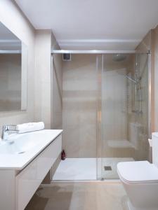 uma casa de banho com um chuveiro, um WC e um lavatório. em Coqueto apartamento, céntrico, con garaje y piscina by Prishomes em Vigo