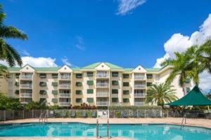 基韋斯特的住宿－The Trinidad by Brightwild-Pool & Parking，一座大型公寓楼,设有游泳池和棕榈树
