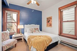 1 dormitorio con cama y pared azul en Charming Parisian Retreat in St Paul: 2 BR 1 bath, en Saint Paul