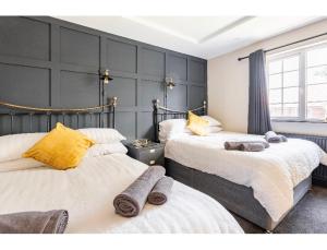 een slaapkamer met 2 bedden en handdoeken bij T'house in wigan in Pemberton