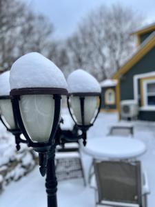 dos luces de la calle cubiertas de nieve en un patio en Belle View Manor Inn en Harbour Grace