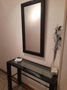 a mirror on a wall with a table with a vase at can tica in Bocairent