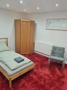 1 dormitorio con 1 cama, 1 silla y 1 armario en Dom pri rieke s parkovaním en Žilina