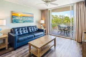 ein Wohnzimmer mit einem blauen Sofa und einem Tisch in der Unterkunft The St Martin by Brightwild-Hot Tub & Pool in Key West